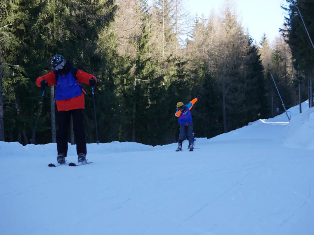 Skifahrer breitet auf der Piste die Arme aus.
